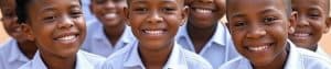 Group of smiling vulnerable children in school uniforms, representing education support and hope for vulnerable youth.