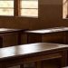 Empty classroom with wooden desks and chairs, highlighting education challenges during the new school term.