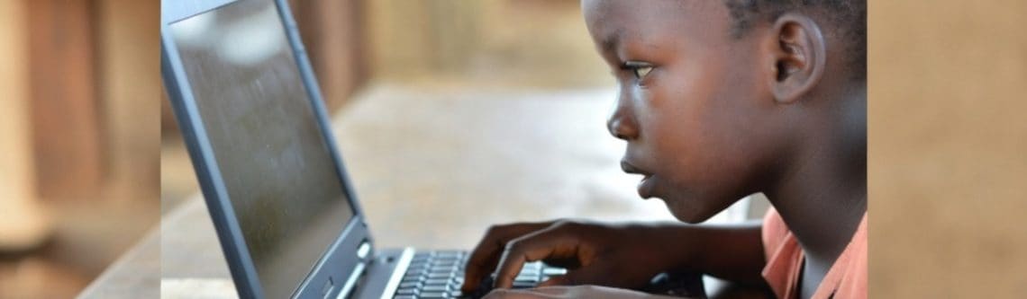 Young student using a laptop for learning, emphasizing the importance of technology in education.