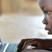 Young student using a laptop for learning, emphasizing the importance of technology in education.