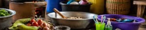 Community kitchen scene with fresh vegetables, cooking utensils, and food preparation tools at Pearl Global Ministries.